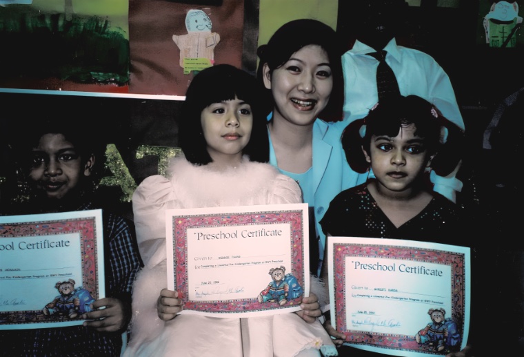 Children displaying preschool certificates