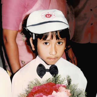 A child in a cap holding a bouquet